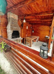 a porch of a log cabin with a table and a fireplace at Vila Craita Zarnesti in Zărneşti