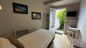 a bedroom with a bed and a sliding glass door at Hotel Le Goeland in Barbâtre