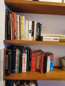 a bunch of books sitting on a book shelf at Grand appartement 4 pers, face aux pistes in La Salle Les Alpes +33 photos