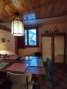 a dining room with a table and chairs and a light at Grand appartement 4 pers, face aux pistes in La Salle Les Alpes