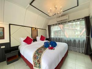 1 dormitorio con 1 cama grande con almohadas rojas y azules en Exclusive Bungalow Near Swiming Pool At Kohchang Resort, en Ko Chang