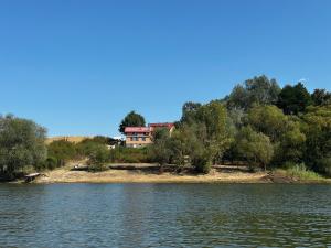 a house on a hill next to a body of water at Lake House Surduc in Fîrdea