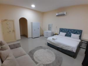 Un dormitorio con una cama y una sala de estar con un sofá. en EK Villa, en Ras al Khaimah