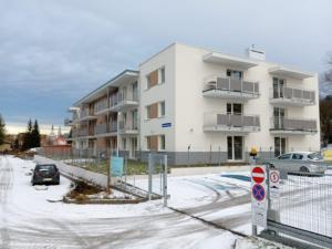 an apartment building in a parking lot with snow at Klonowa 4 4 in Kamienna Góra
