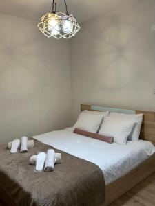 une chambre avec un lit avec des draps blancs et un lustre dans l'établissement The Studio Apartment, à Ohrid