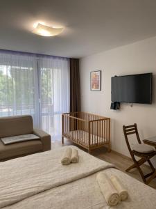 a living room with two beds and a baby crib at Vízipók apartman in Csopak