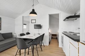 una cucina e una sala da pranzo con tavolo e sedie di First Camp Holbæk Fjord a Holbæk