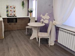 a kitchen with a white table and chairs in a room at Студия в центре города in Kryvyi Rih