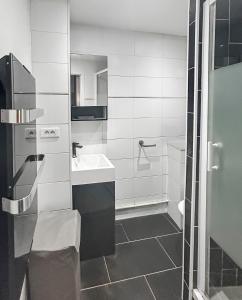 ein weißes Badezimmer mit Waschbecken und Toilette in der Unterkunft Studio Le Montebello - Vintage, WiFi et Netflix in Fontainebleau + 5 Fotos