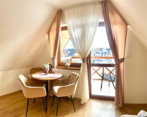 a table and chairs in a room with a window at Na Skarpie in Białka Tatrzanska