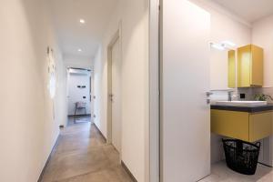 un corridoio con lavandino e un bagno di ELVY Garda Living Garden a Riva del Garda Altre 50 foto