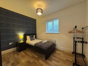 1 dormitorio con 1 cama y una pared grande en Badgers House - 6 Bedrooms, Sleeps 14, Parking, Wifi, en Wroughton