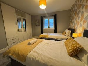 Un dormitorio con dos camas y una ventana en Badgers House - 6 Bedrooms, Sleeps 14, Parking, Wifi, en Wroughton