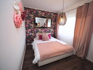 a bedroom with a bed and a mirror on the wall at Le Jardin d'Eden by Leslodgespa in Blotzheim