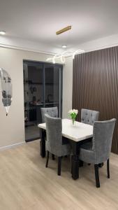 una mesa de comedor con sillas y un jarrón de flores. en Lex Place Syokimau, en Syokimau