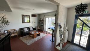 a living room with a couch and a table at Hotel Le Goeland in Barbâtre +65 photos