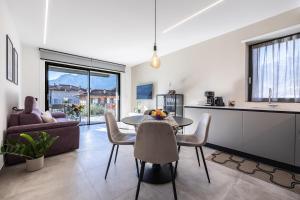 una cucina e un soggiorno con tavolo e sedie di ELVY Garda Living Garden a Riva del Garda