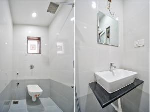 a white bathroom with a sink and a toilet at Baga Creek Side Nest in Baga +21 photos