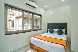 a bedroom with a bed and a window at Baga Creek Side Nest in Baga