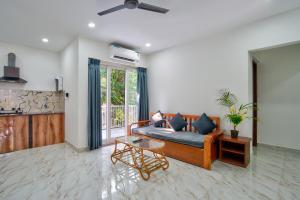 a living room with a couch and a table at Baga Creek Side Nest in Baga