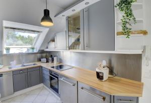 a kitchen with white cabinets and a wooden counter top at Dünengras in Schausende +28 photos