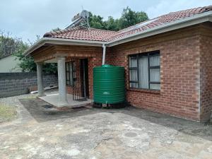 a house with a green water tank in front of it at Cozy 2 Bedroom in Newcastle
