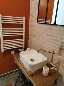 a bathroom with a white sink on a wooden table at Le puech des Amandiers in Villeneuve-sur-Vère +6 photos