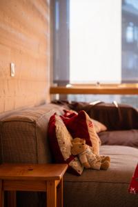 a teddy bear sitting on a couch next to a table at Les Berlicants in Mijoux