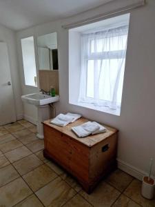 a bathroom with a bath tub and a sink and a window at Large Victorian Townhouse in Buxton +20 photos