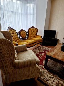 a living room with two chairs and a couch at Large Victorian Townhouse in Buxton