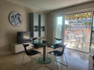 ein Esszimmer mit Glastisch und Stühlen in der Unterkunft Le Cambridge Juan in Antibes