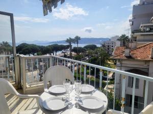Ein Tisch und Stühle auf einem Balkon mit Aussicht in der Unterkunft Le Cambridge Juan in Antibes