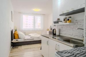 a kitchen with a sink and a bed in a room at Apartman Sweet home in Humenné