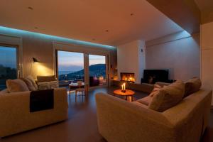 a living room with two couches and a fireplace at Joy Villa Agia Marina in Aghia Marina