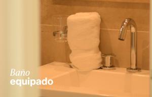 a roll of toilet paper sitting on top of a sink at Filiberto by iPPA in Buenos Aires
