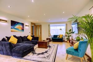 a living room with a blue couch and chairs at Lovely South Downs Town House in Upper Beeding
