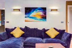 a blue couch with yellow pillows in a living room at Lovely South Downs Town House in Upper Beeding +31 photos