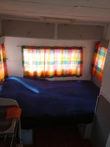 シエラ・デ・ラ・ベンターナにあるTiny House Ventaniaの窓のある小さな部屋のベッド