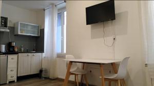 eine Küche mit Tisch und Stühlen in einem Zimmer in der Unterkunft RDC cosy en centre ville in Narbonne