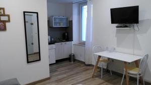 eine kleine Küche mit einem Tisch und einem TV an der Wand in der Unterkunft RDC cosy en centre ville in Narbonne