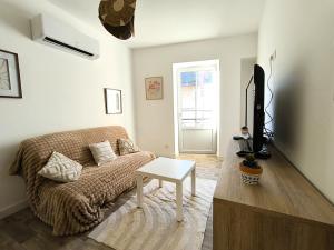 Una sala de estar con un sofá y un televisor. en Le Talia - Terrasse, en Auch