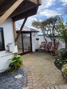 a patio with rocking chairs and a house at Sea Breeze in Poole