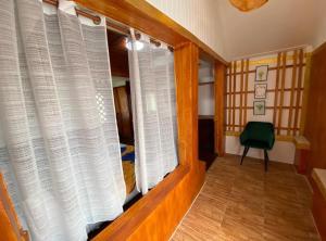 einen Flur mit weißen Vorhängen und einem grünen Stuhl in der Unterkunft Family Bungalow Near Beach At Kohchang Resort in Ko Chang