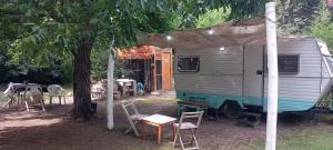 シエラ・デ・ラ・ベンターナにあるTiny House Ventaniaのテーブルと椅子の横に停めたrv