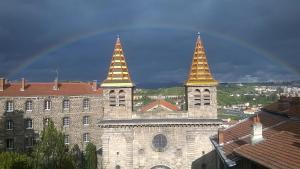 a building with two towers with a rainbow in the background at Studio indépendant contre la Cathedrale - ancien couvent - 4eme etage sans ascenseur in Le Puy-en-Velay