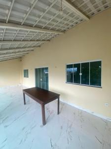 een grote kamer met een houten tafel op een witte muur bij Hospedagem da Lili in Palmas