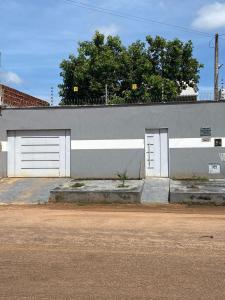 een grijs en wit gebouw met twee garagedeuren bij Hospedagem da Lili in Palmas