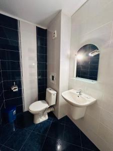 a bathroom with a white toilet and a sink at Hotel Energy in Kiten