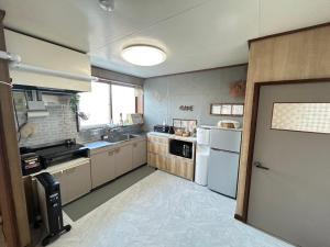 a large kitchen with a sink and a refrigerator at JaM in Noboribetsu