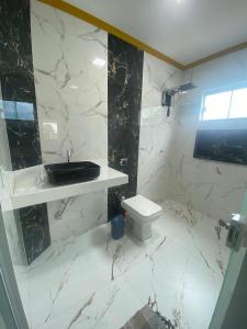 een badkamer met een wastafel en een toilet bij Hospedagem da Lili in Palmas